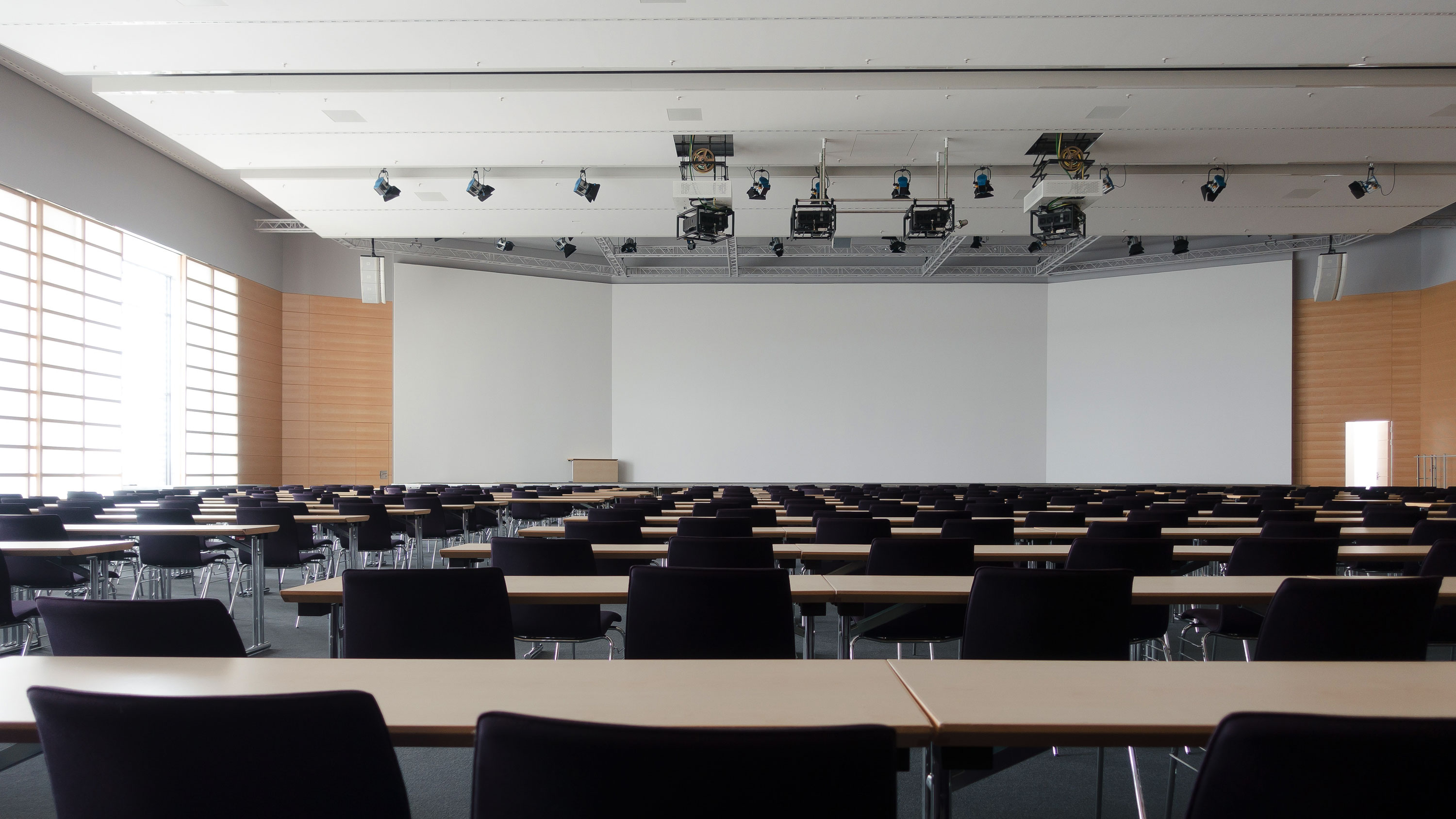 Classroom with large whiteboard at front, tables in rows