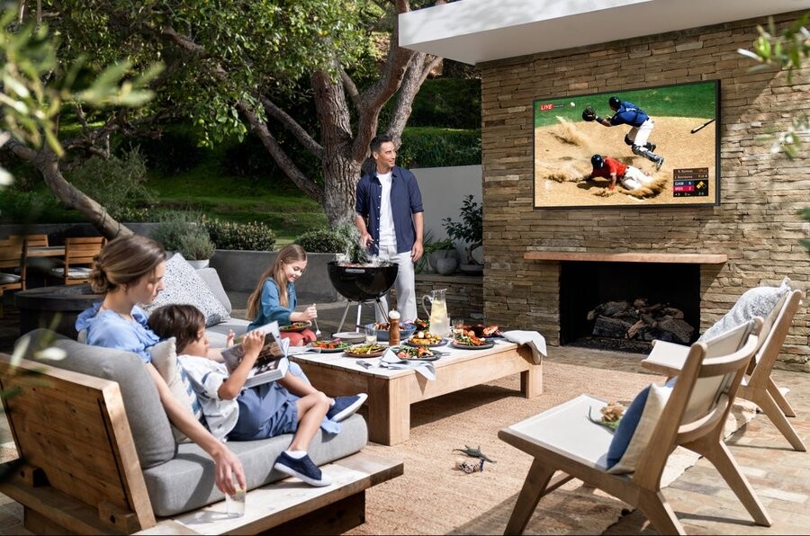 A family enjoying their outdoor TV installation in their backyard.