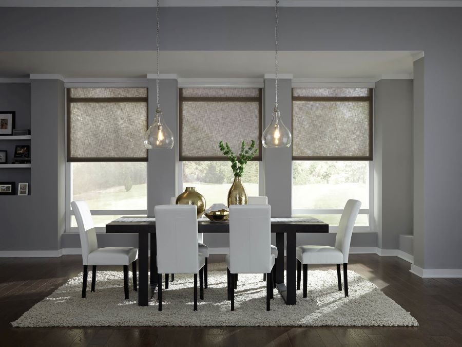 Lutron shades halfway drawn in a dining area with sunlight filtering through.