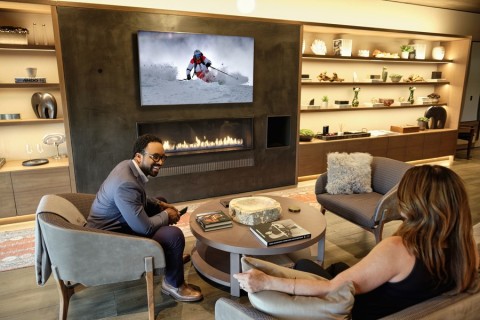 Two people talking in the living room while watching the TV.