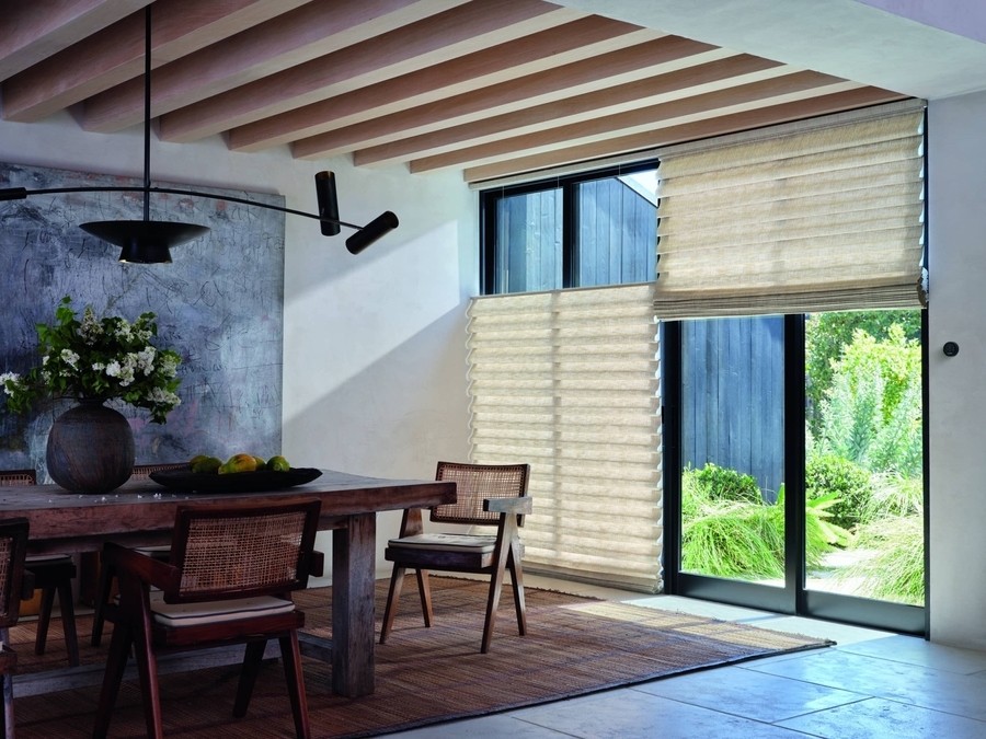 Hunter Douglas cellular shades installed on floor-to-ceiling windows in a contemporary dining room.