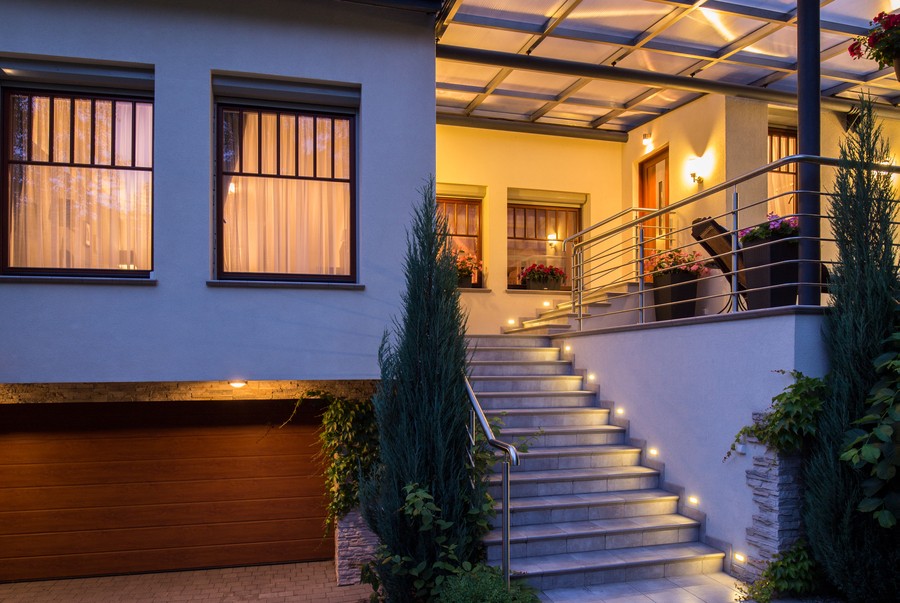 Front steps of a house illuminated by landscape lighting. 